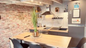 a kitchen with a wooden table and a brick wall at Top Loft Perles 4 des Châteaux in Mer +13 photos