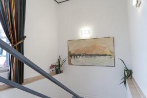 a painting hanging on a wall next to a staircase at Petit Wannsee GmbH in Berlin
