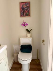 a bathroom with a toilet with a purple flower on it at Modern Cotswolds Studio in Bishops Cleeve