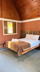 a bedroom with a large bed in a brick wall at Pousada e Camping Carrion in Itu +289 photos