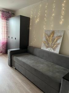 a couch in a living room with lights on the wall at Затишна трьохкімнатна квартира у Львові in Lviv