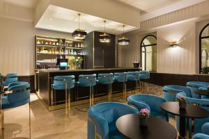 a restaurant with blue chairs and a bar at Le Grand Hôtel Dieu by SOWELL COLLECTION in Nîmes