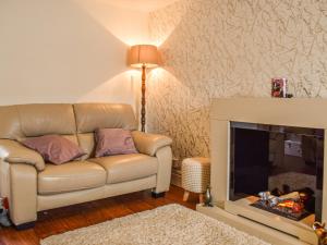 ein Wohnzimmer mit Sofa und Kamin in der Unterkunft Ardvar in Crail