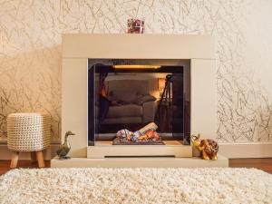 ein weißer Kamin in einem Wohnzimmer mit einer Couch in der Unterkunft Ardvar in Crail + 10 Fotos