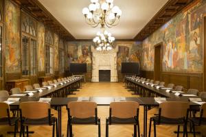 a conference room with tables and chairs and paintings at Le Grand Hôtel Dieu by SOWELL COLLECTION in Nîmes
