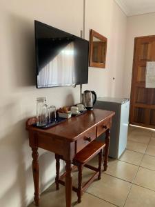 a wooden table with a television on top of it at Lens BnB Guesthouse in Benoni