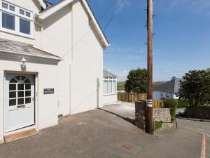 a white house with a white door and a pole at Berrystead Upper Flat in Salcombe