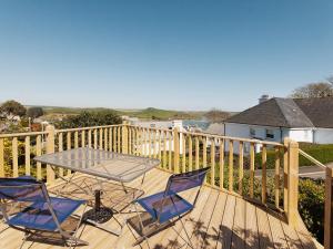 two chairs and a table on a deck at Berrystead Upper Flat in Salcombe