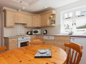 a kitchen with wooden cabinets and a wooden table at Berrystead Upper Flat in Salcombe