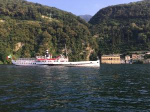 a large boat on the water near a mountain at Como Luxury Rooms in Como