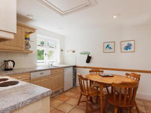a kitchen with a wooden table and chairs at Berrystead Upper Flat in Salcombe +6 photos