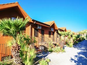 a house with palm trees in front of it at Torre Sant'Irene Club in Sant'Irene-Briatico