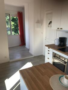 a kitchen with white cabinets and a wooden floor at Un petit nid au calme, à 4 minutes de la plage ! in Banyuls-sur-Mer +2 photos