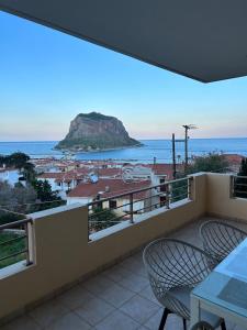 a balcony with chairs and a view of the ocean at Blue Hour in Monemvasia