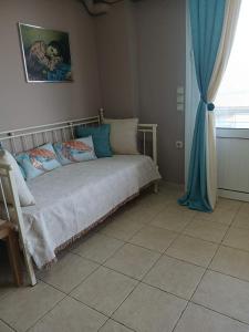 a bedroom with a bed with blue curtains and a window at Blue Hour in Monemvasia