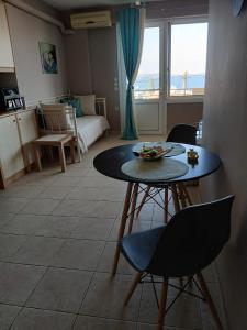 a living room with a table and a room with a bed at Blue Hour in Monemvasia