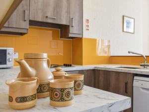 a kitchen with a counter with three vases on it at Whitby Apartment in Commondale