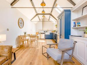 a kitchen and living room with a table and chairs at The Old Workshop - Cottage in Broom