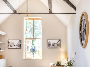 a living room with a clock on the wall at The Old Workshop - Cottage in Broom