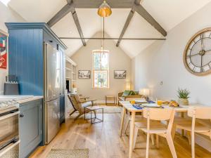 a kitchen and living room with a table and chairs at The Old Workshop - Cottage in Broom +25 photos