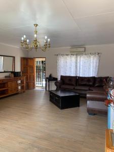 a living room with a couch and a chandelier at Lens BnB Guesthouse in Benoni