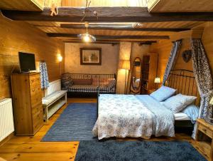a bedroom with a bed and a couch in a room at Chambre Fleur bleue, les Volets Bleus in Laneuvelotte