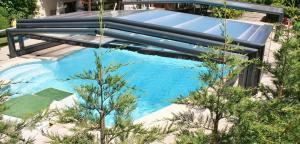 a swimming pool in the middle of a yard with trees at Chambre Fleur bleue, les Volets Bleus in Laneuvelotte