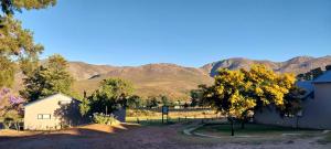a view of a farm with mountains in the background at Mountain Pastures Game Lodge in Uniondale