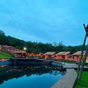 a group of houses next to a body of water at Pousada Via Láctea in Três Cachoeiras