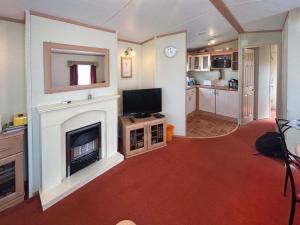 a living room with a fireplace and a television at 136 Lakeside in Burnham on Sea