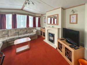 a living room with a couch and a television at 136 Lakeside in Burnham on Sea