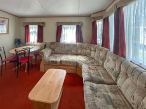 a living room with a large couch and a table at 136 Lakeside in Burnham on Sea
