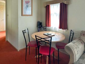 a living room with a table and chairs and a couch at 136 Lakeside in Burnham on Sea