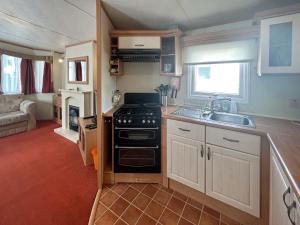 a kitchen with a stove and a sink in a caravan at 136 Lakeside in Burnham on Sea +3 photos