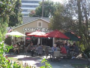 a group of people sitting at tables under umbrellas at Pensacola Victorian Bed & Breakfast in Pensacola