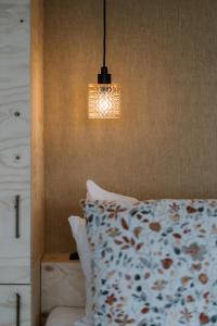 a bedroom with a bed with a pillow and a light at Polderlodge de Verademing in Goudriaan