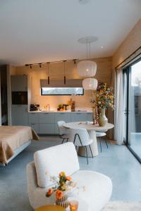 a room with a bed and a table and a kitchen at Polderlodge de Verademing in Goudriaan
