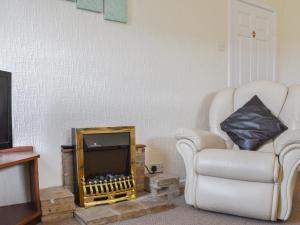 a living room with a chair and a television at Farndale Apartment in Commondale