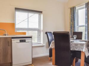 a kitchen and dining room with a table and chairs at Farndale Apartment in Commondale