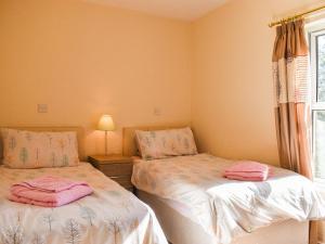 two beds in a bedroom with pink towels on them at Farndale Apartment in Commondale +5 photos