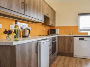 a kitchen with wooden cabinets and a counter top at Farndale Apartment in Commondale