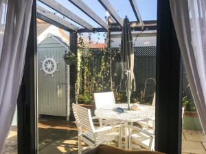 a patio with a table and chairs and an umbrella at The Coach House in Whitstable