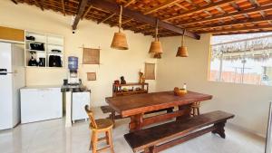 a kitchen with a wooden table and a refrigerator at Vila Lençóis Residence in Santo Amaro