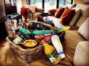 a basket filled with food and drinks in a living room at The Coach House in Whitstable