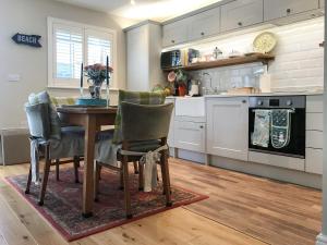 a kitchen with a table and chairs in a kitchen at The Coach House in Whitstable