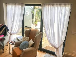 a living room with a chair and a sliding glass door at The Coach House in Whitstable