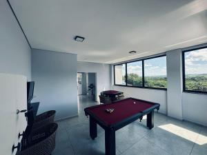 a pool table in a room with windows at Charles Hotel in Pôrto Ferreira