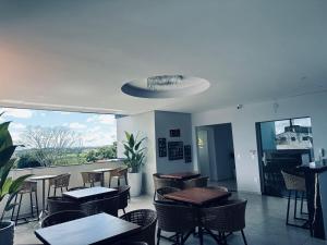 a restaurant with tables and chairs and a balcony at Charles Hotel in Pôrto Ferreira