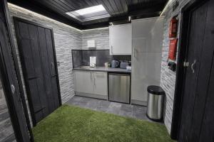 a small kitchen with white cabinets and a green rug at Glamping Domes in Articlave