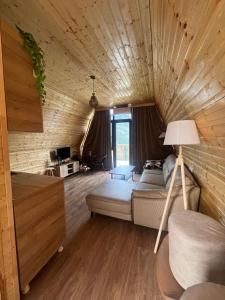 a bedroom with a bed in a wooden room at Chalet Adjara in Okʼropilauri